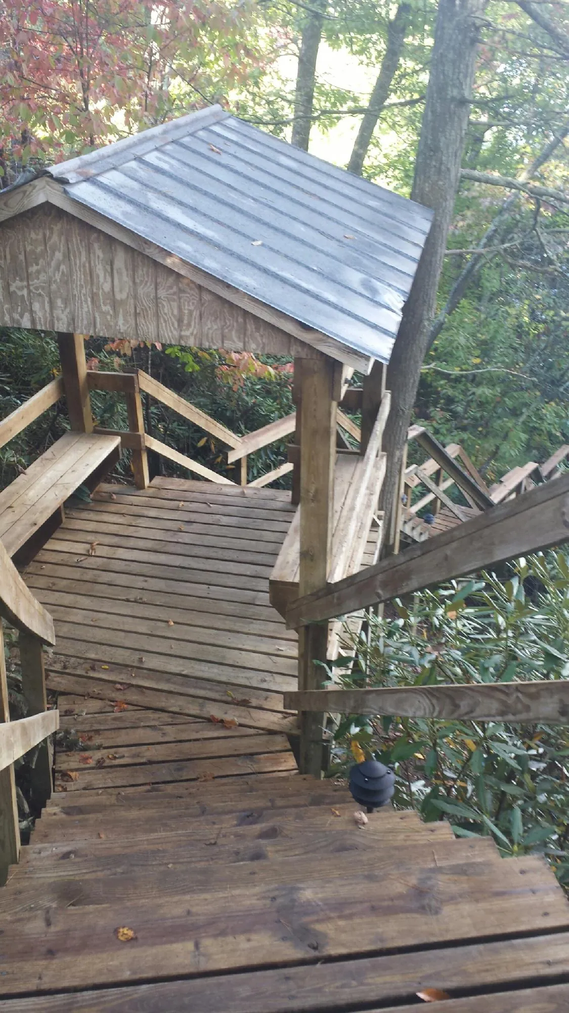 Metal roofed shelter over wooden steps on a wooded walkway — Skylight Repair & Installation work by our crew in Columbus